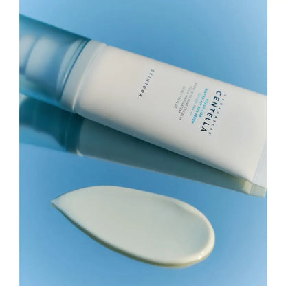 SKIN1004 Hyalu-Cica Water-Fit Sun Serum – tub și textura cremei pe fundal albastru